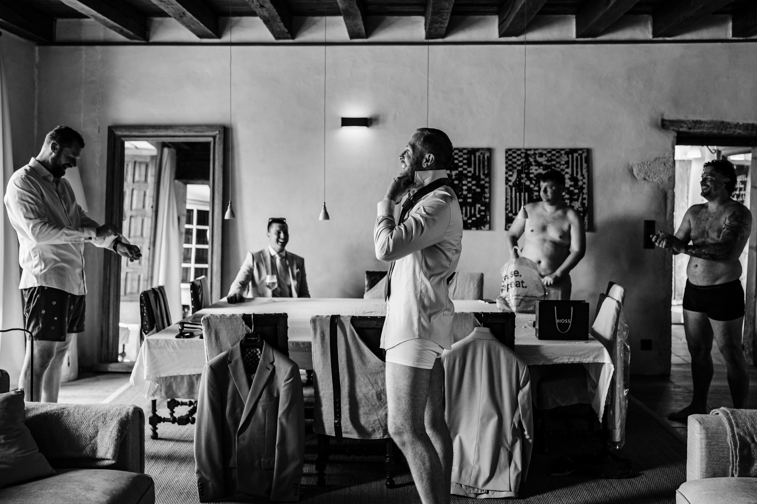 Groom and groomsmen getting ready together downstairs in the chateau