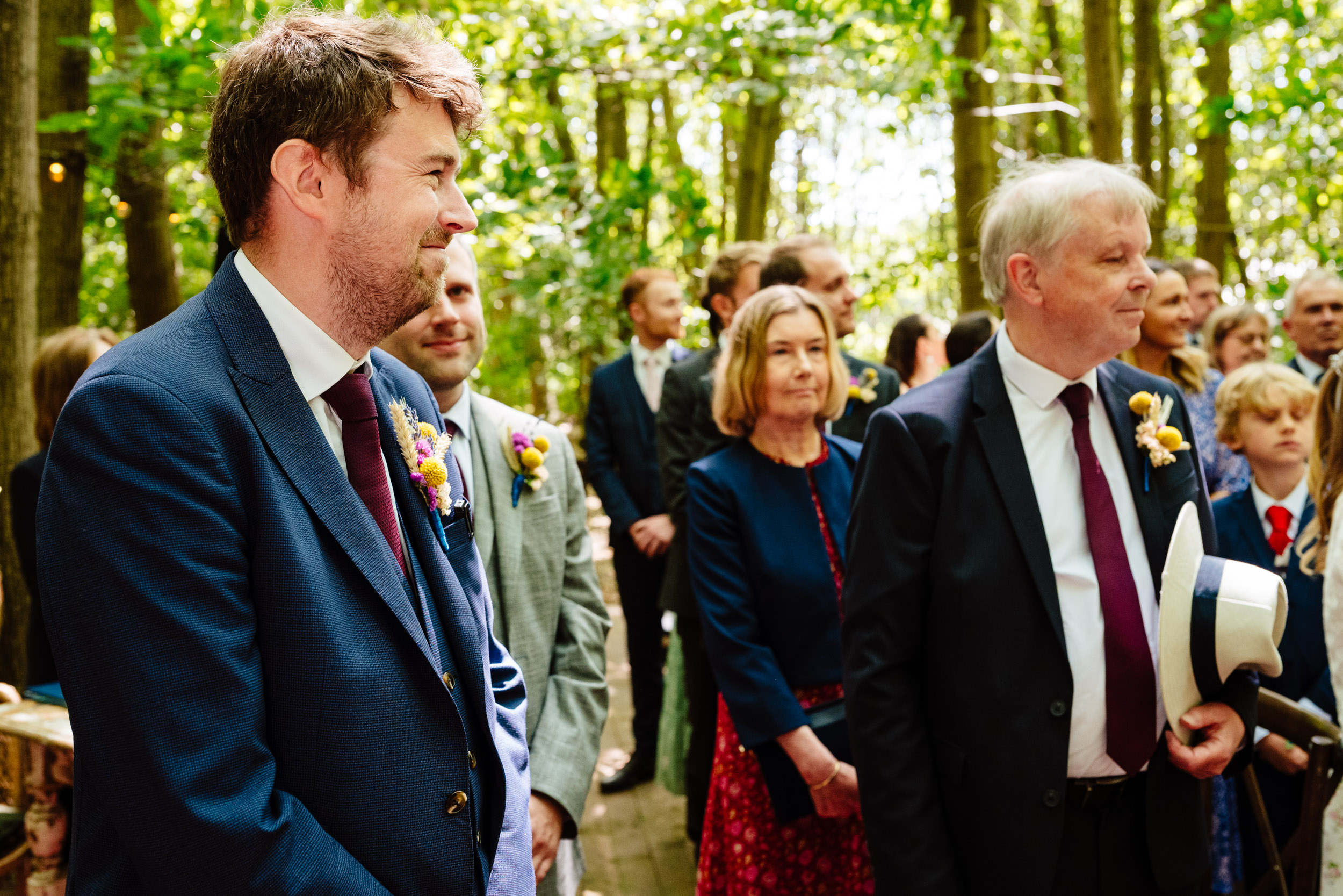 Groom watching the bride as she walks down the aisle during the ceremony at The Dreys