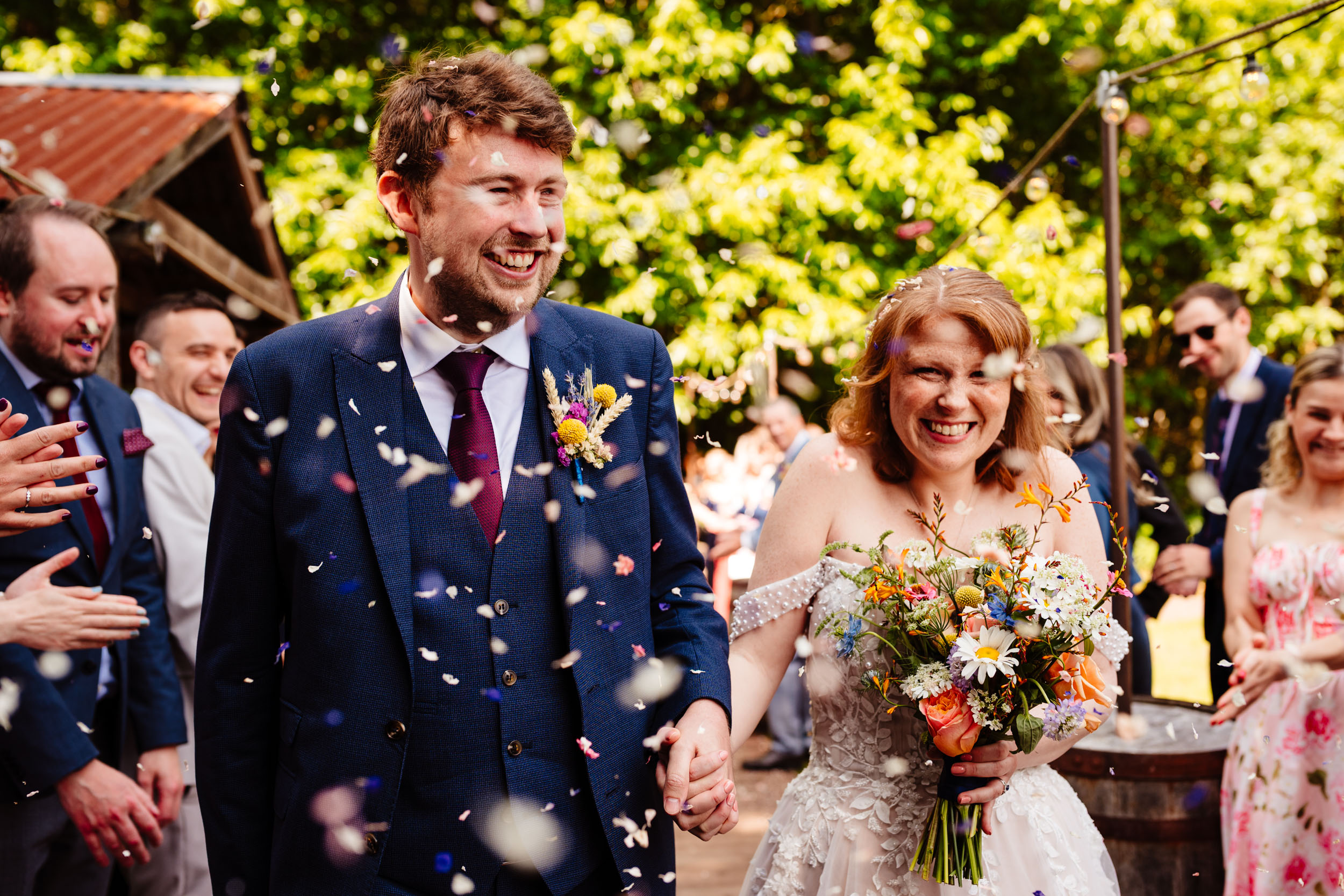 Bride and groom walking through confetti after the ceremony at The Dreys