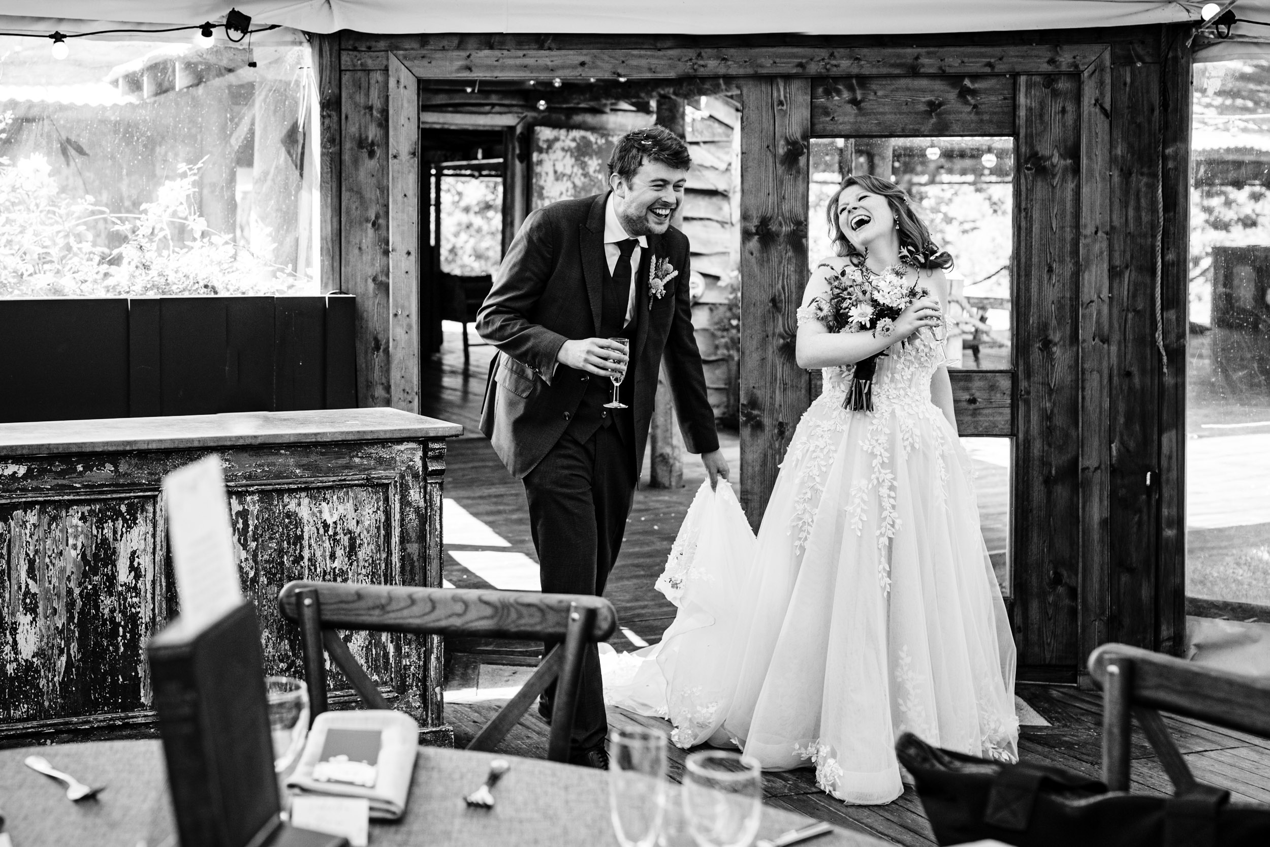 Bride and groom entering the dining area laughing together during the reception