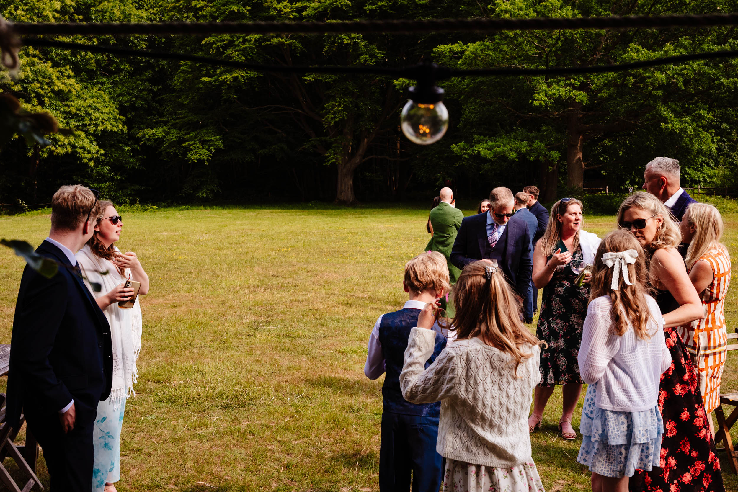 Wedding guests chatting outside during the reception drinks hour at The Dreys