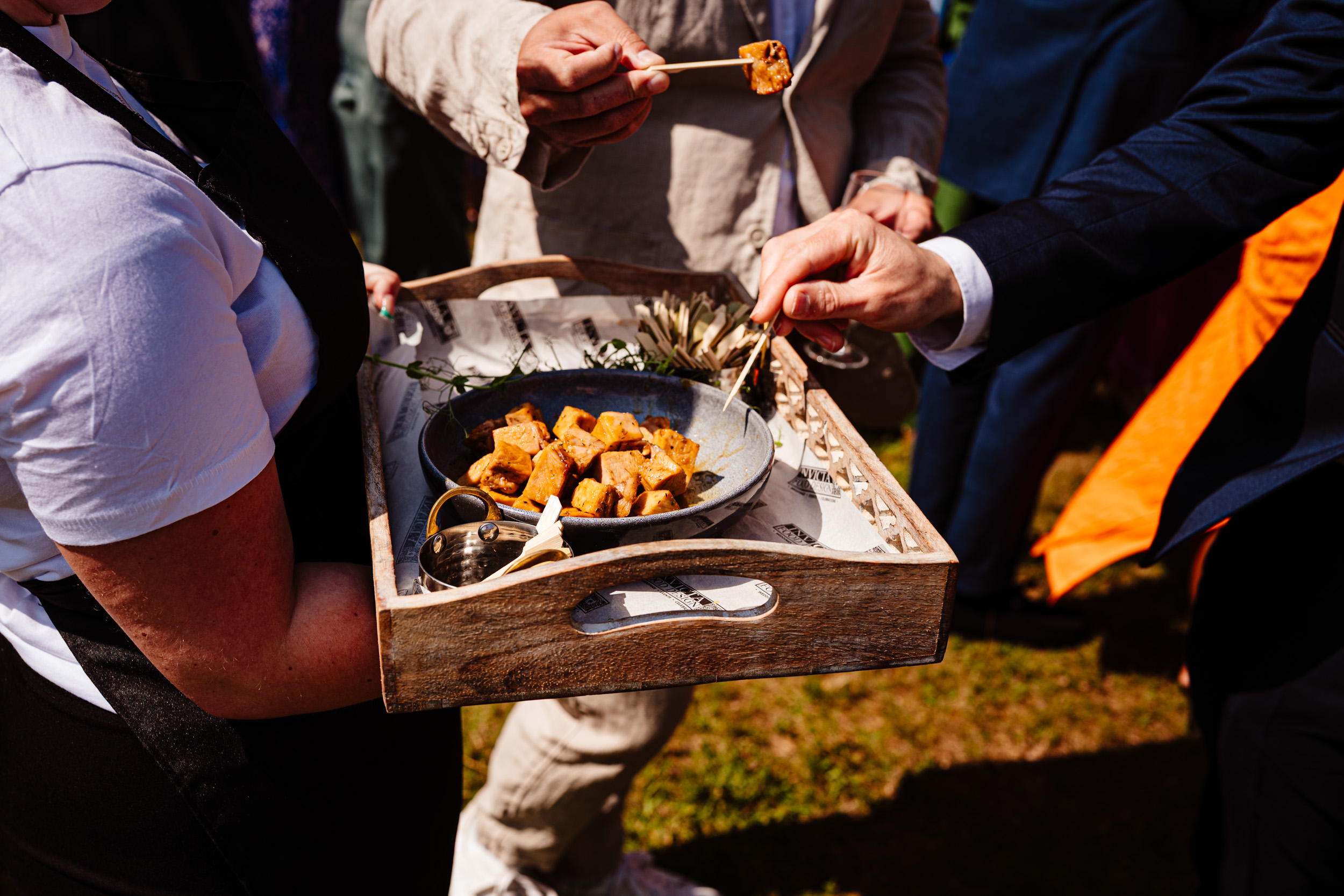 Guest picking up a canapé with a toothpick during the drinks reception