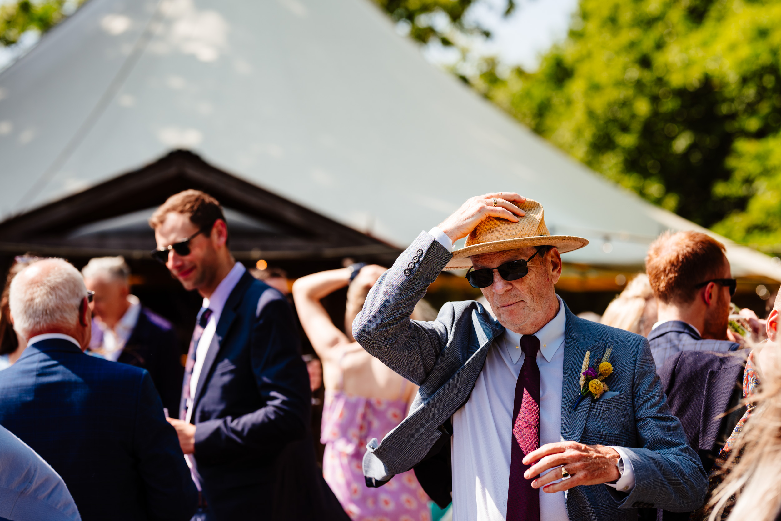 Bride’s dad adjusting his hat while looking into the frame