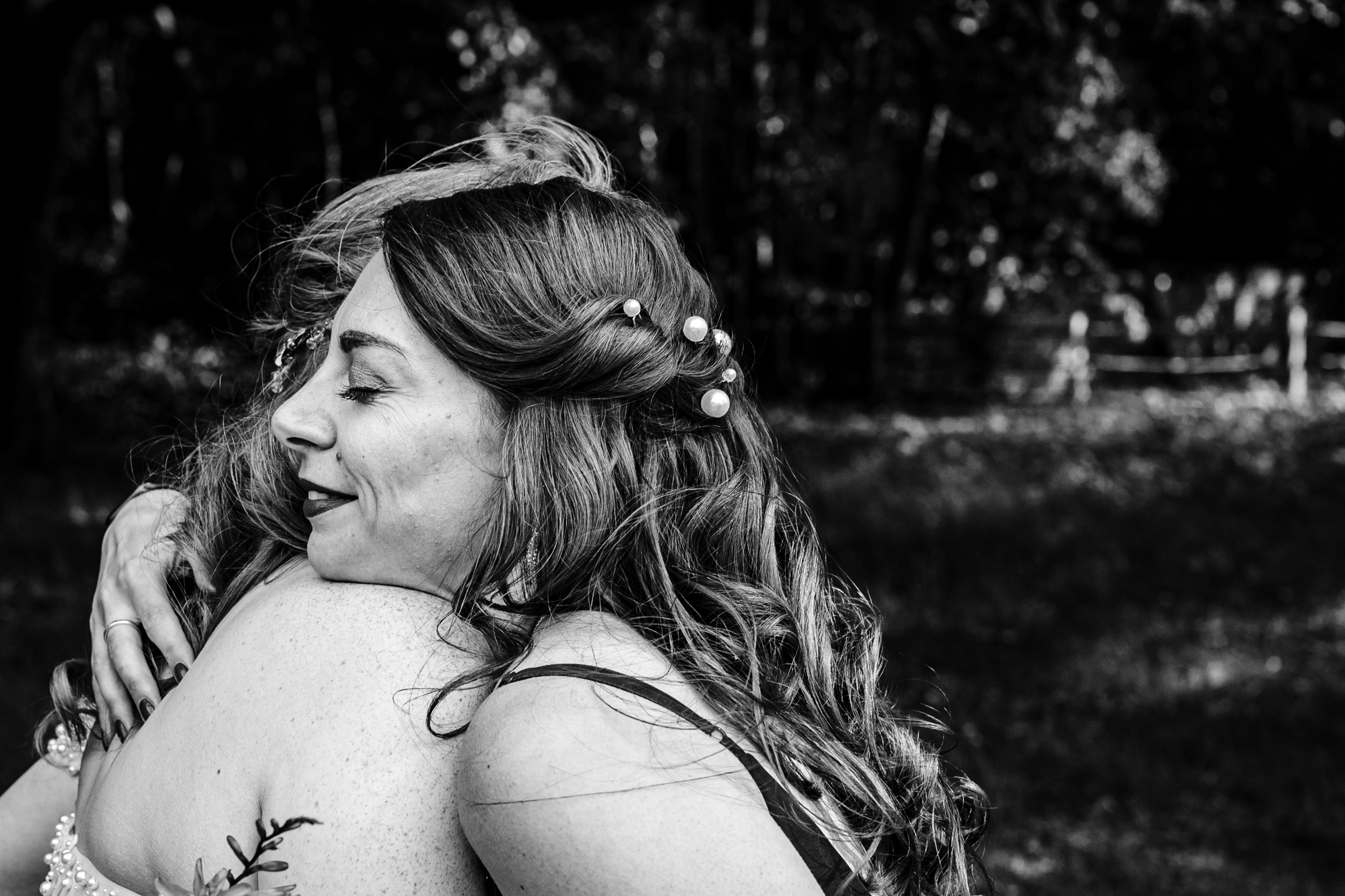 Bride sharing a heartfelt hug with a bridesmaid during the celebrations