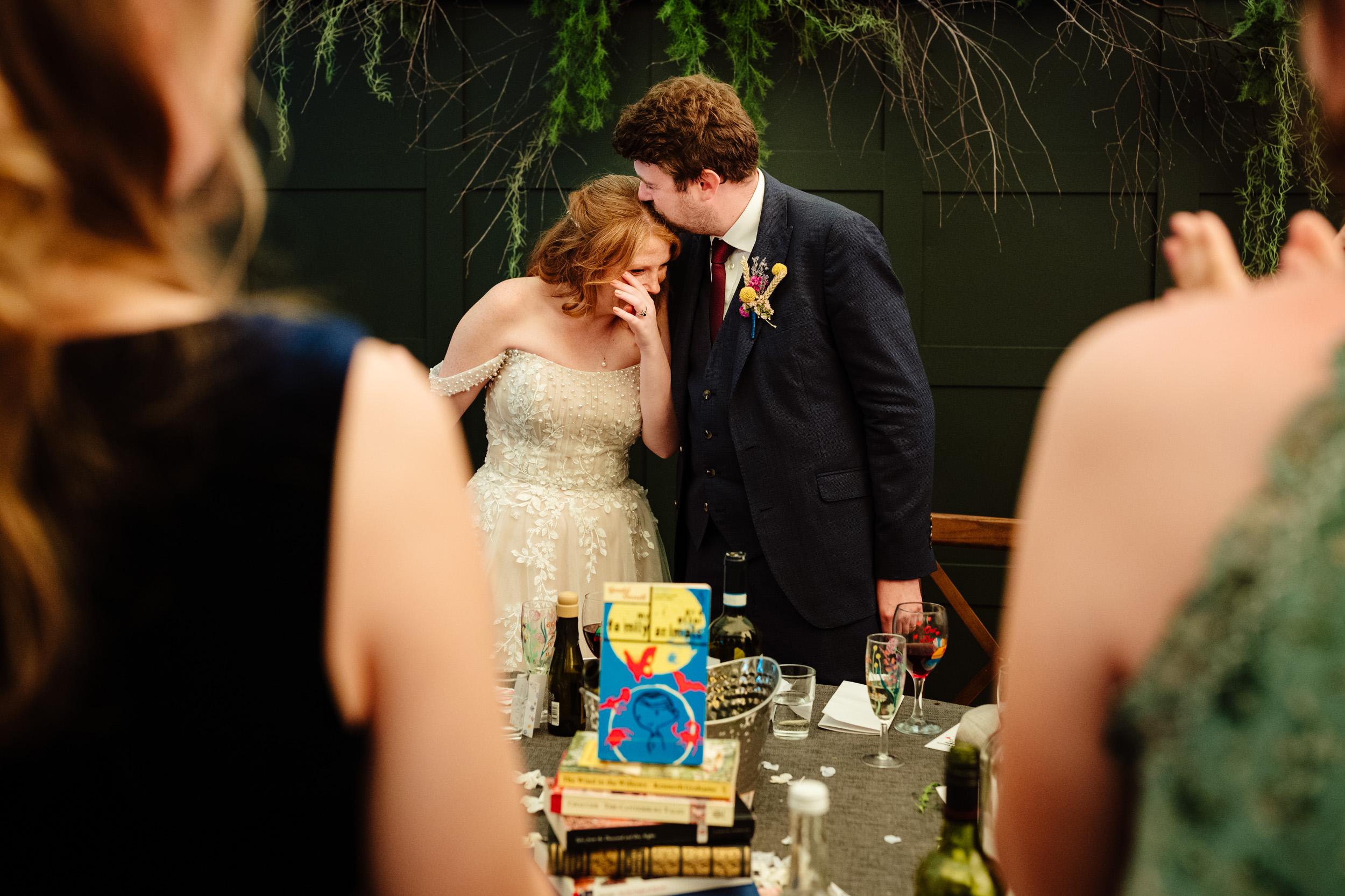 Bride and groom sharing a tender kiss at the top table