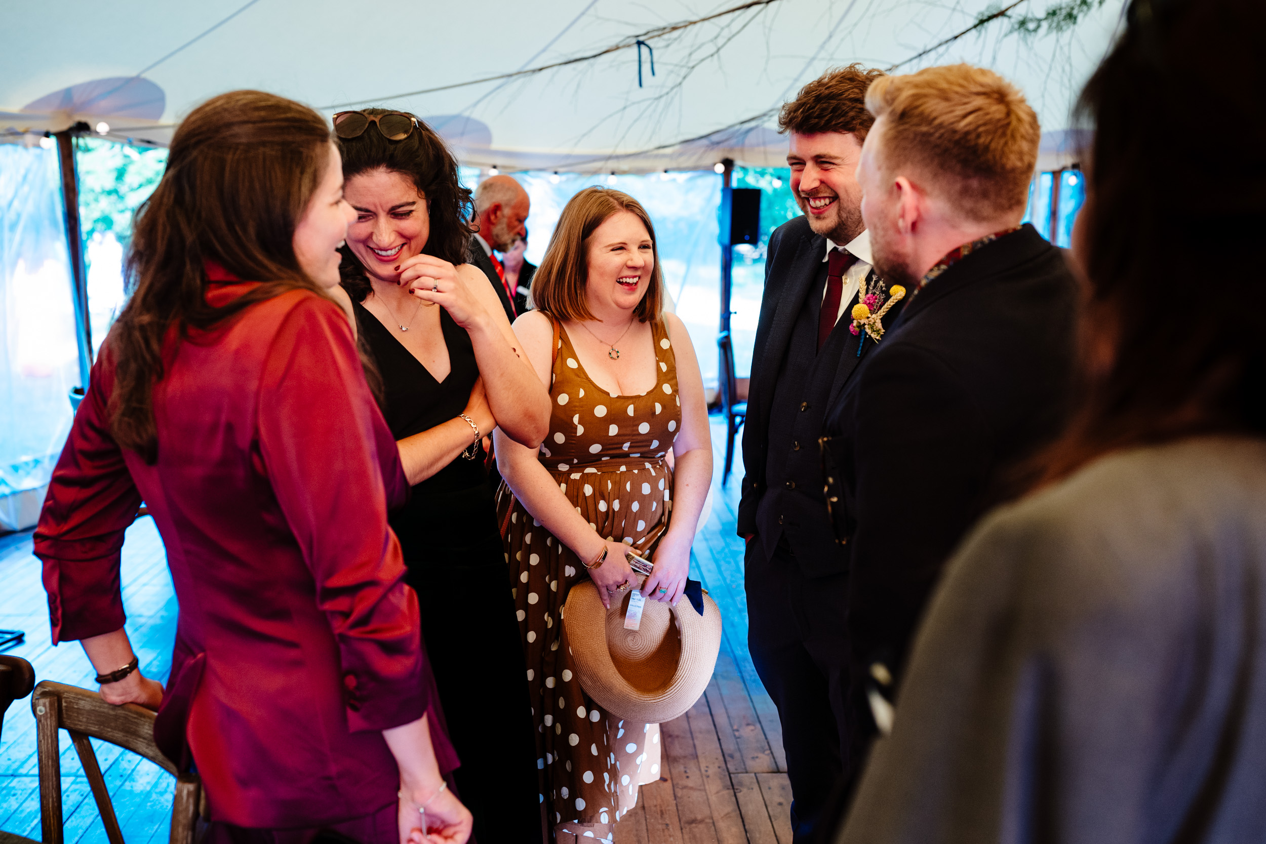 Groom laughing with wedding guests during the evening reception