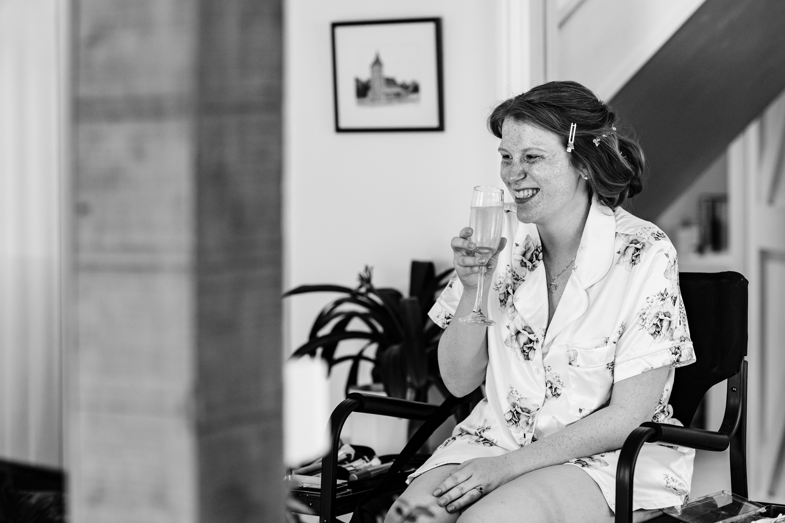 Bride laughing just before taking a sip from her champagne glass