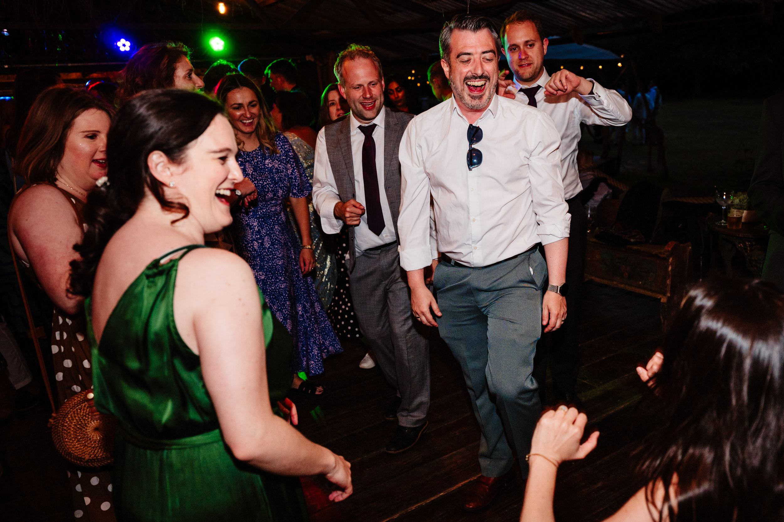Wedding guests laughing together on the dance floor