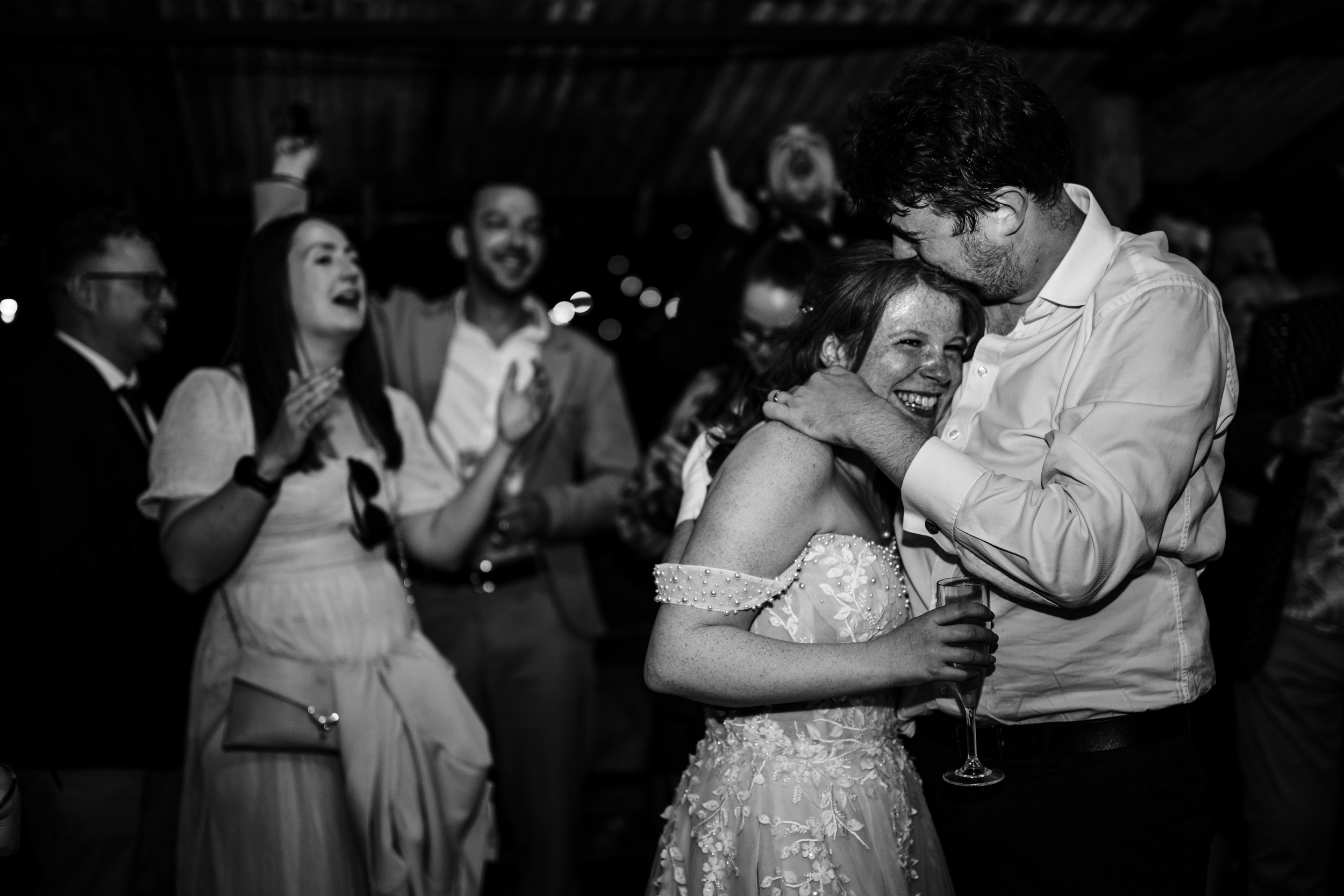 Groom kissing the bride on the head during the evening celebrations