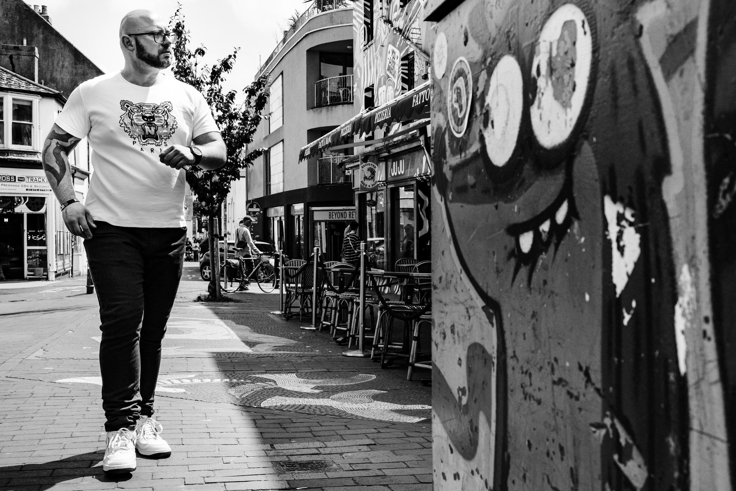 A guy walking down the road in Brighton.