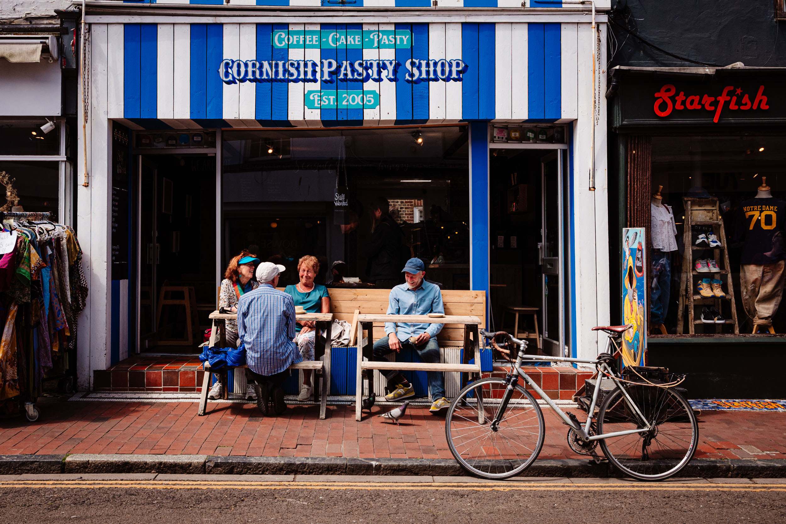 People having a coffee outside in a blue cafe in Brighton.