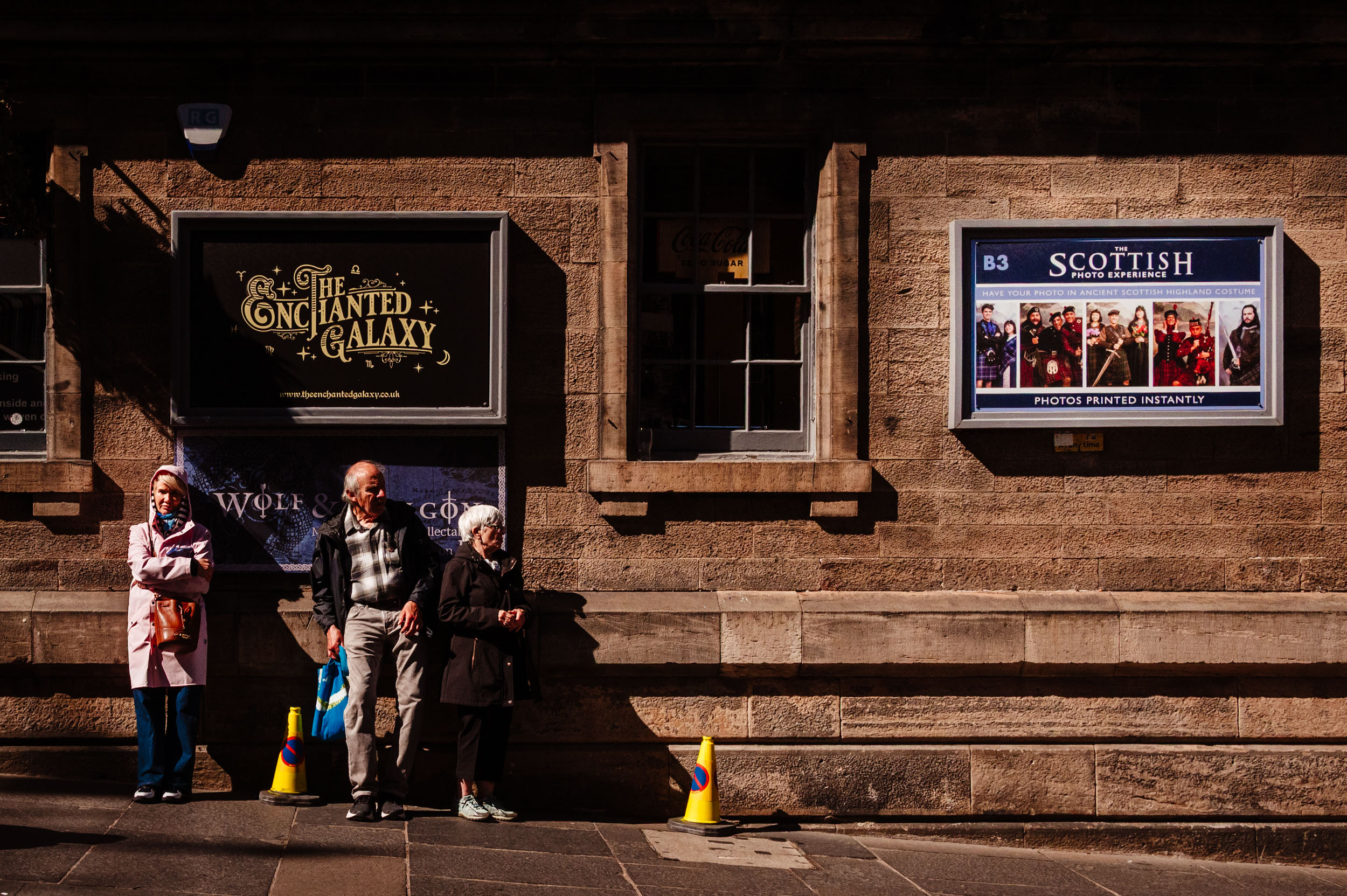 A group of Scotsmen waiting on the pavement.