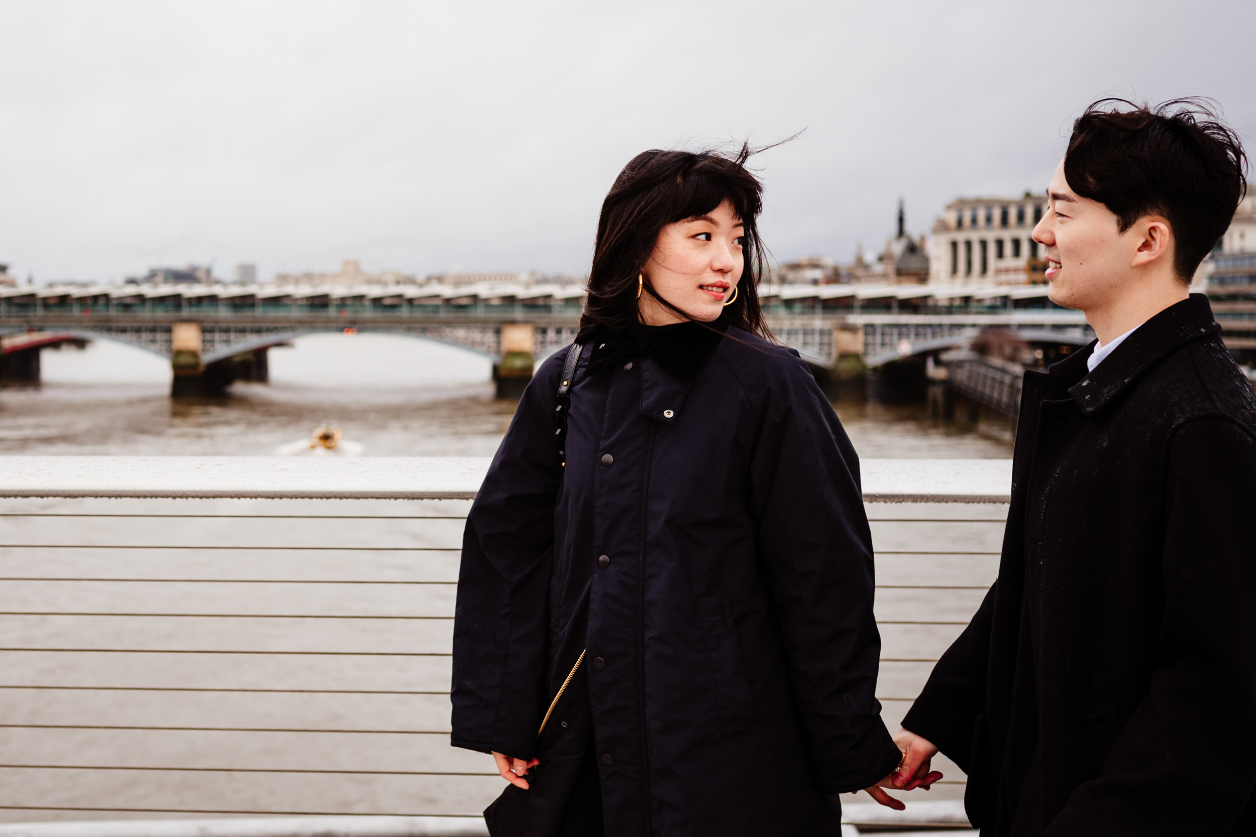 She looks back at him while walking on Millennium Bridge after their proposal.