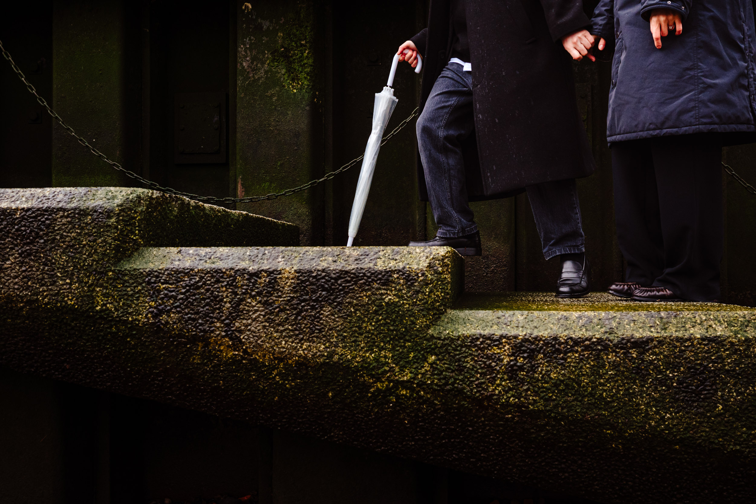 Close-up of their hands holding as they walk up the steps after the proposal.