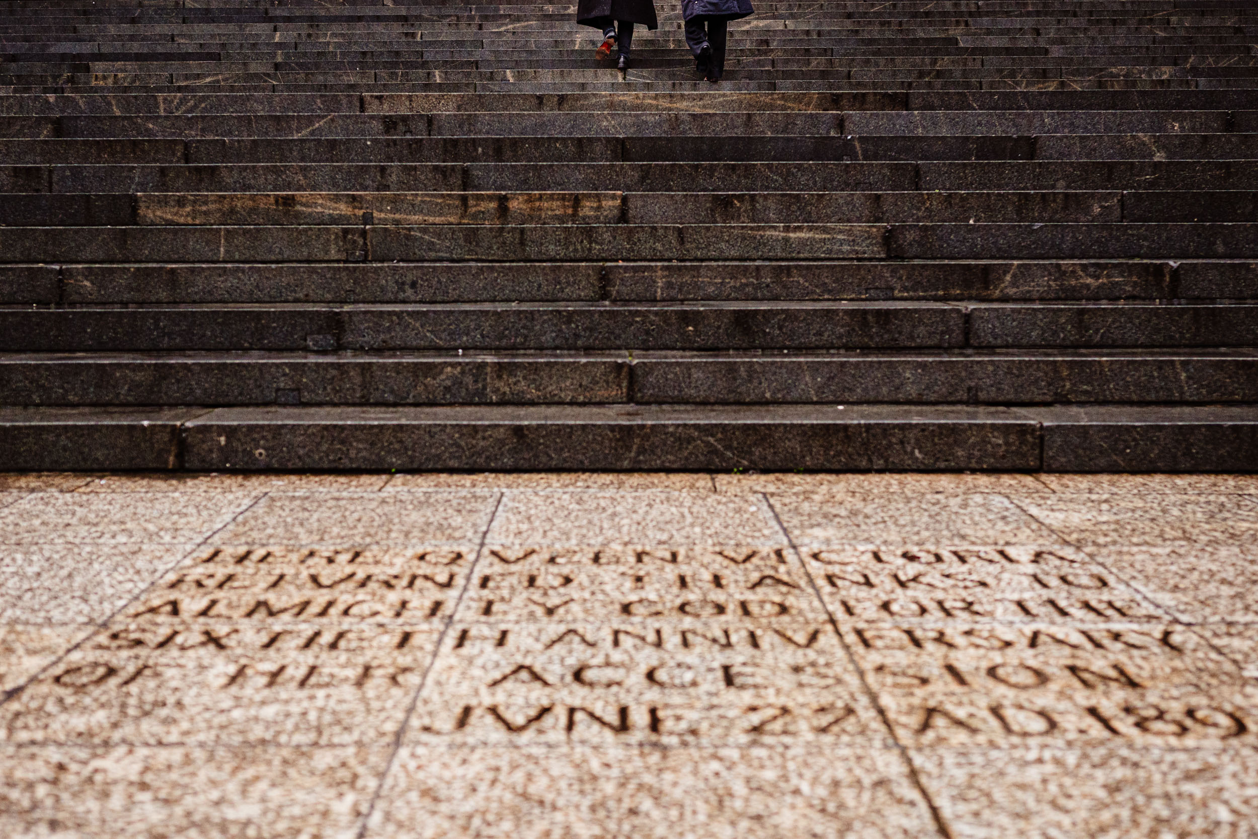 Couple standing at the top of the steps at St Paul’s Cathedral after getting engaged.