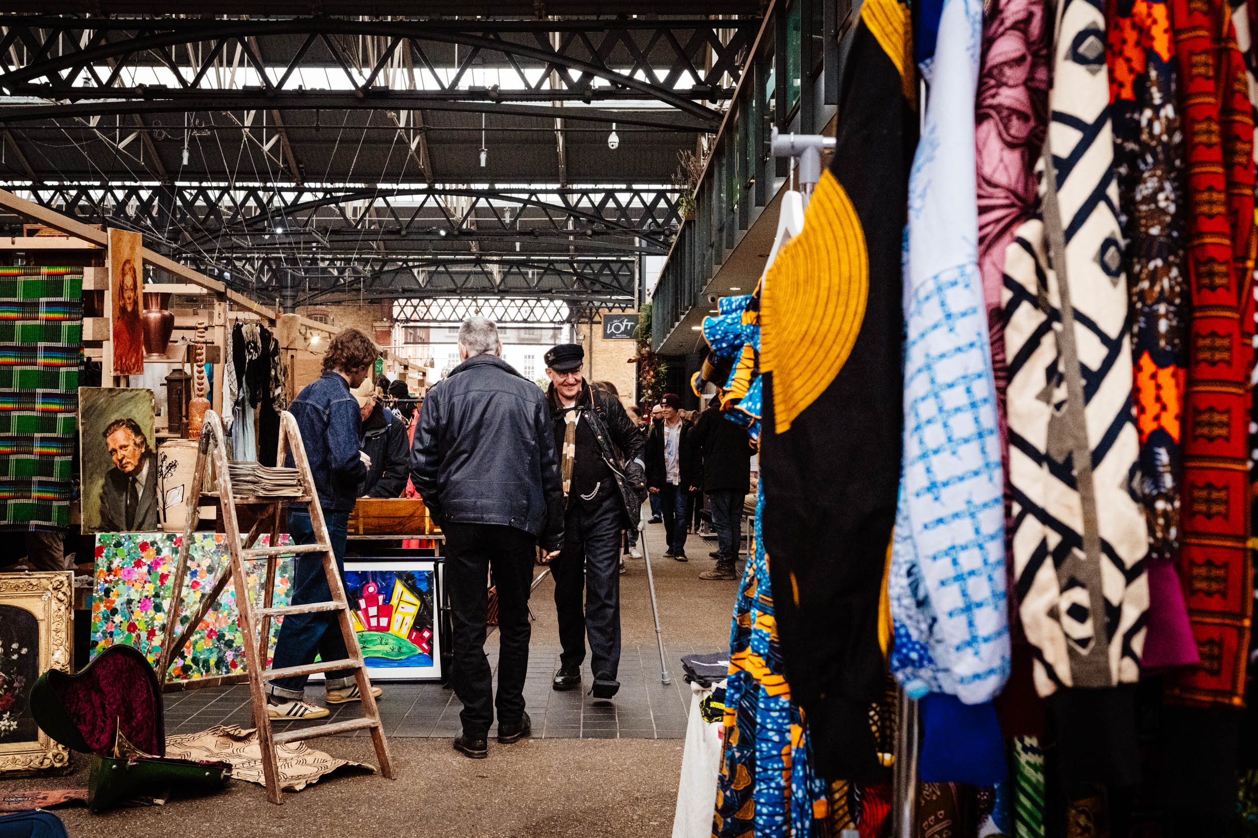 A man greets somebody he knows in a London market.