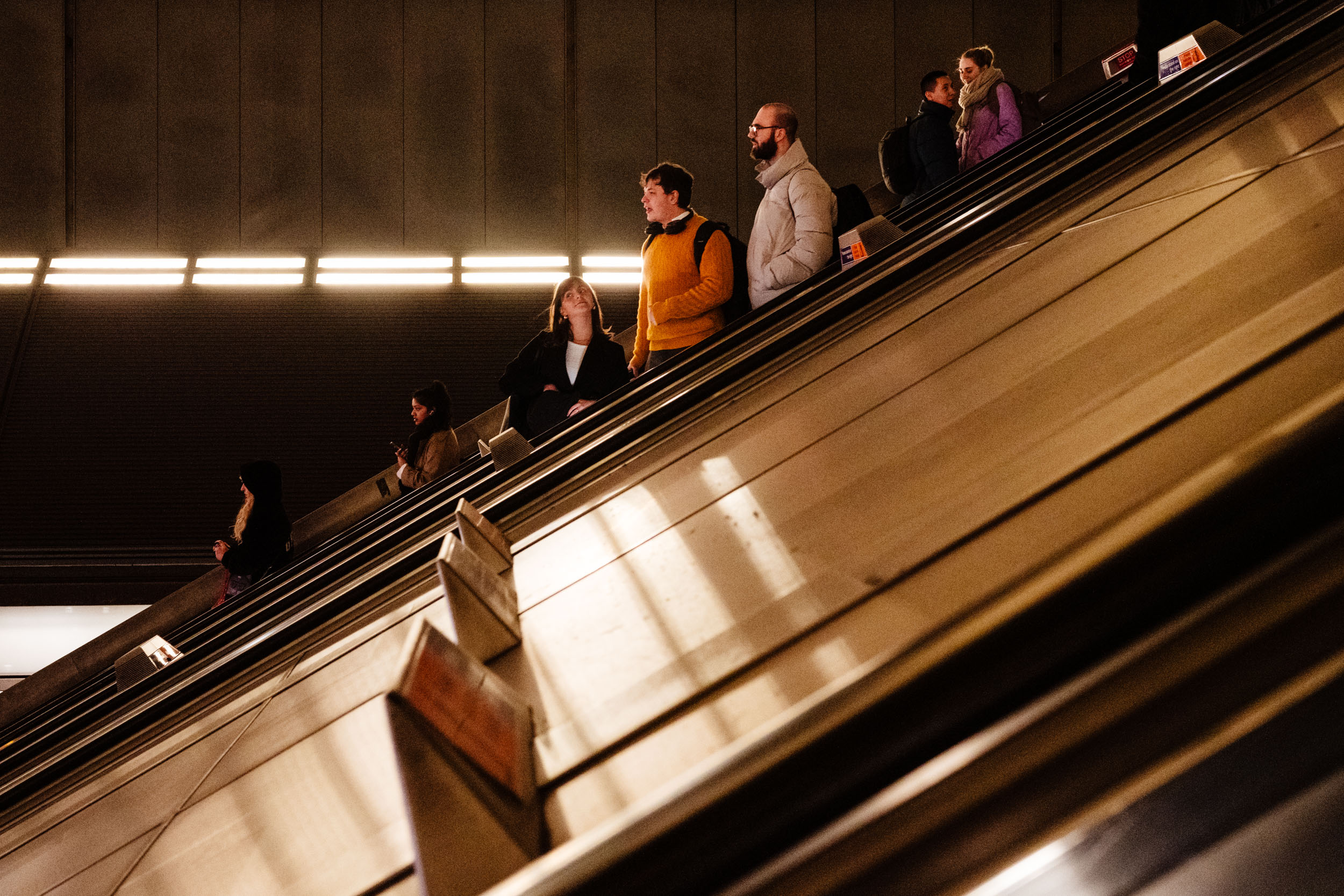 People coming down the escalator in a tube station in London.