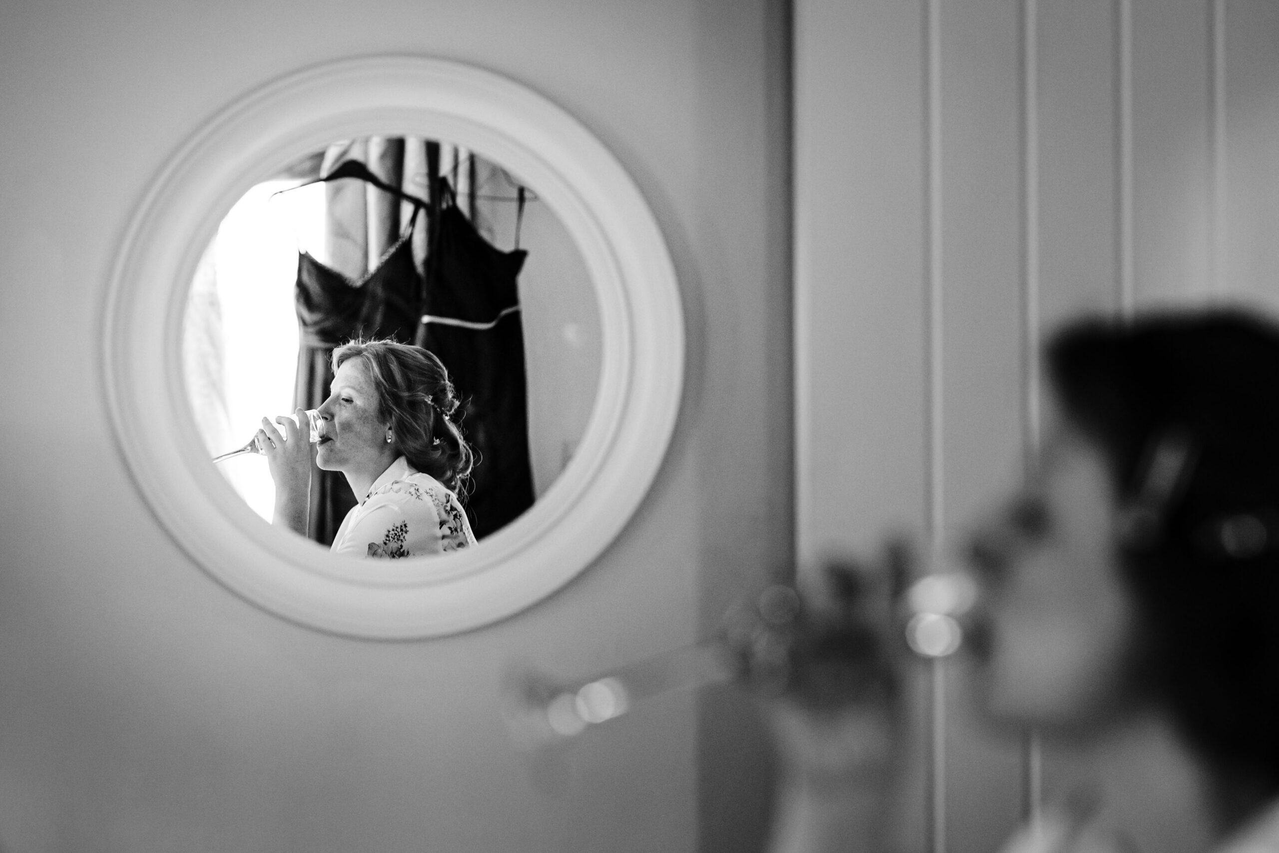 Bride reflected in a circular mirror during wedding morning preparations at The Dreys wedding venue in Kent.