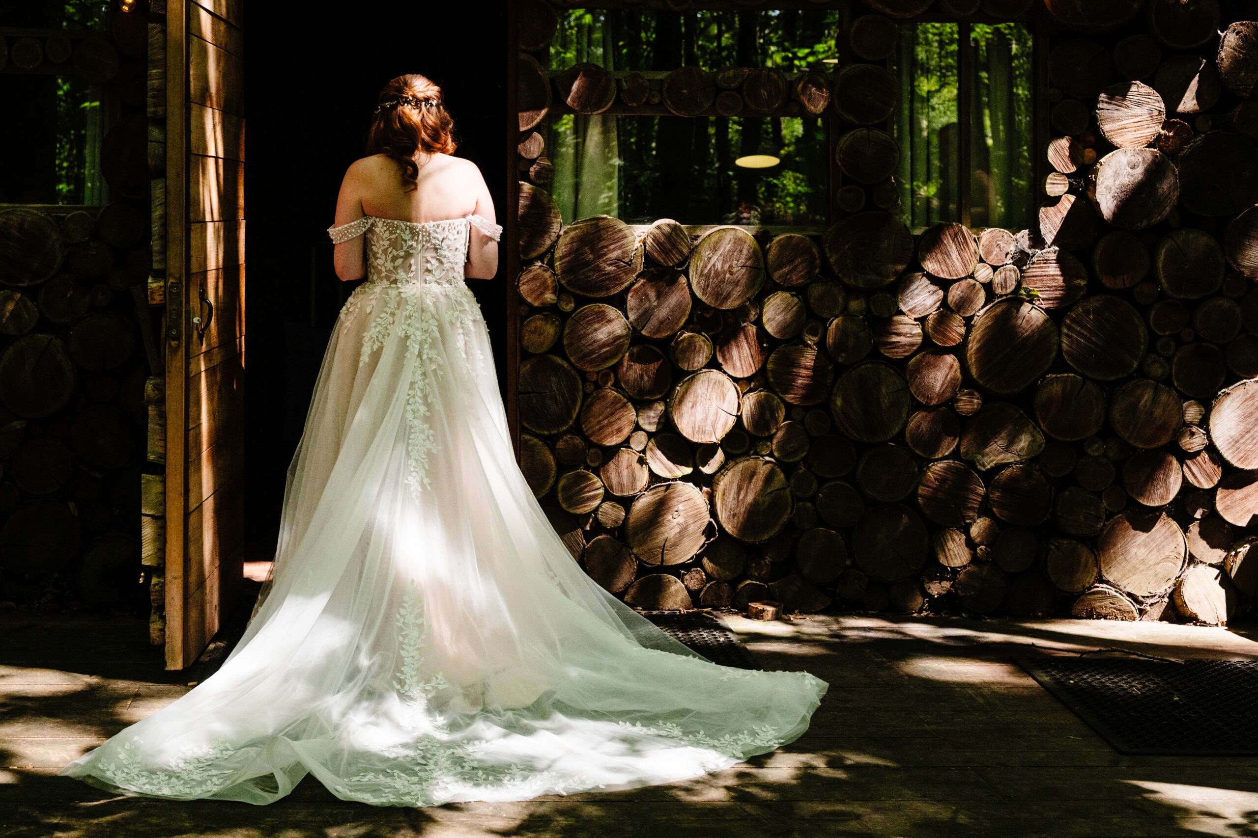 Bride standing in sunlight before her outdoor woodland wedding ceremony at The Dreys.