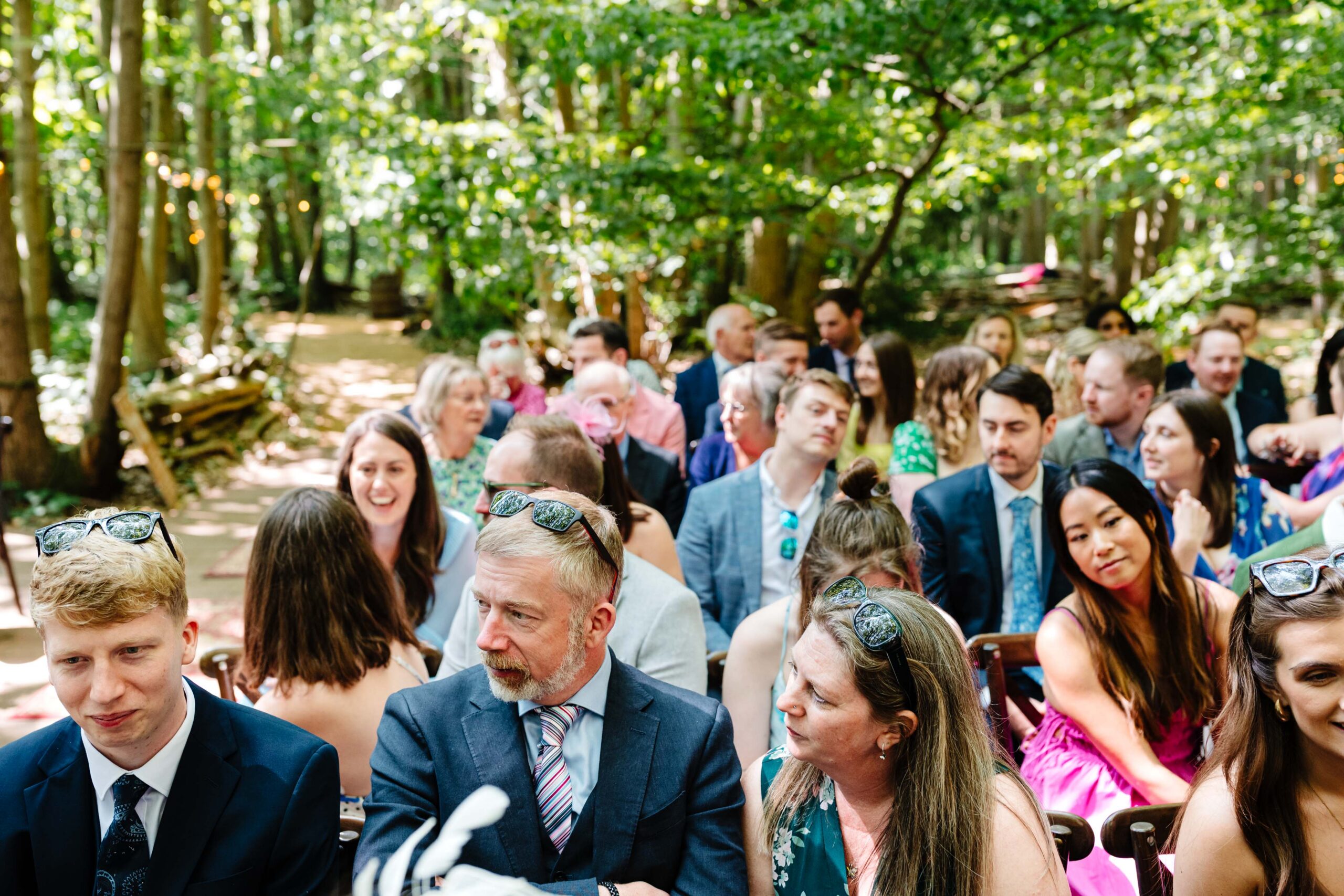 Guests seated for an outdoor woodland wedding ceremony at The Dreys in Kent.