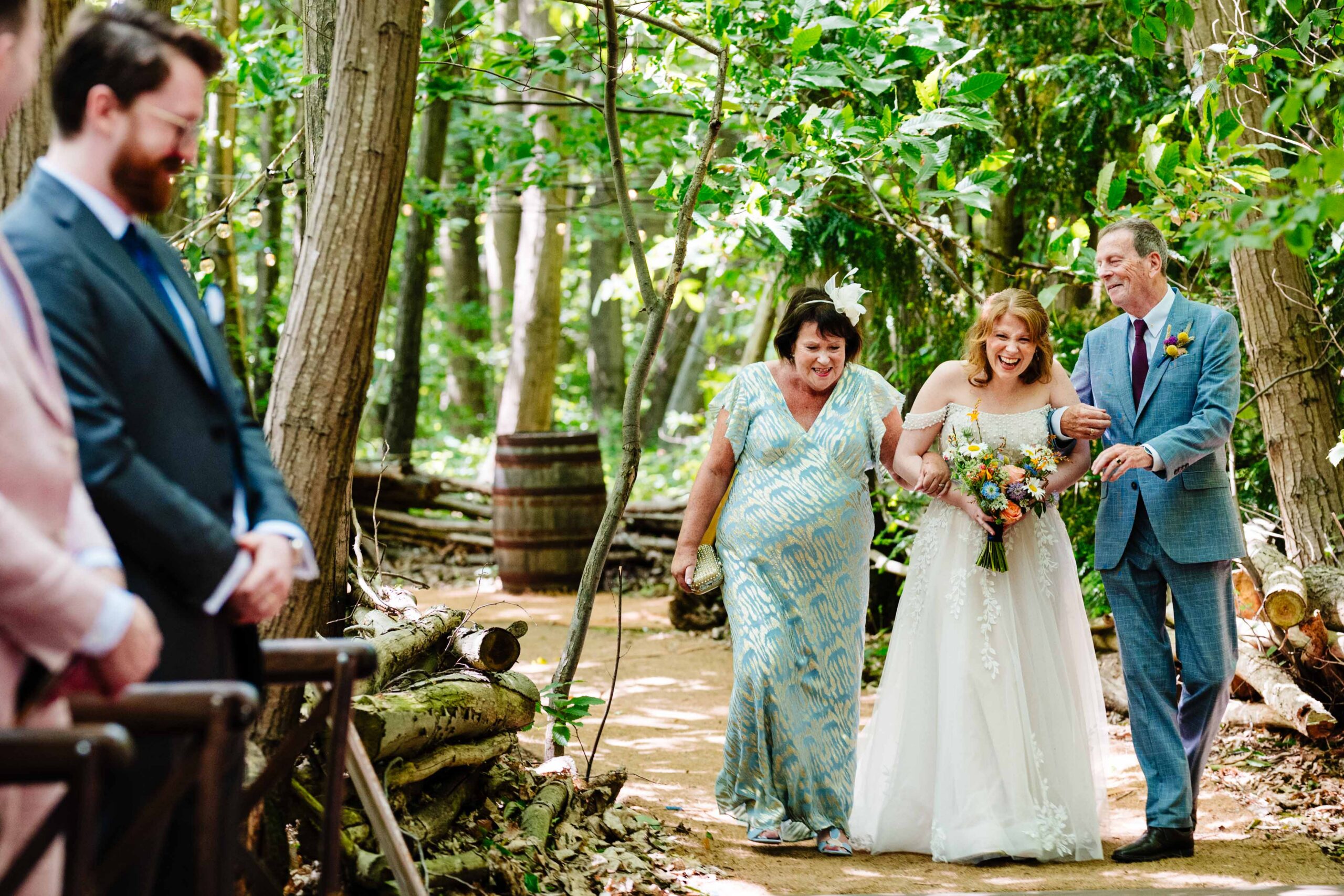 Bride walking down the aisle during a woodland wedding ceremony at The Dreys.