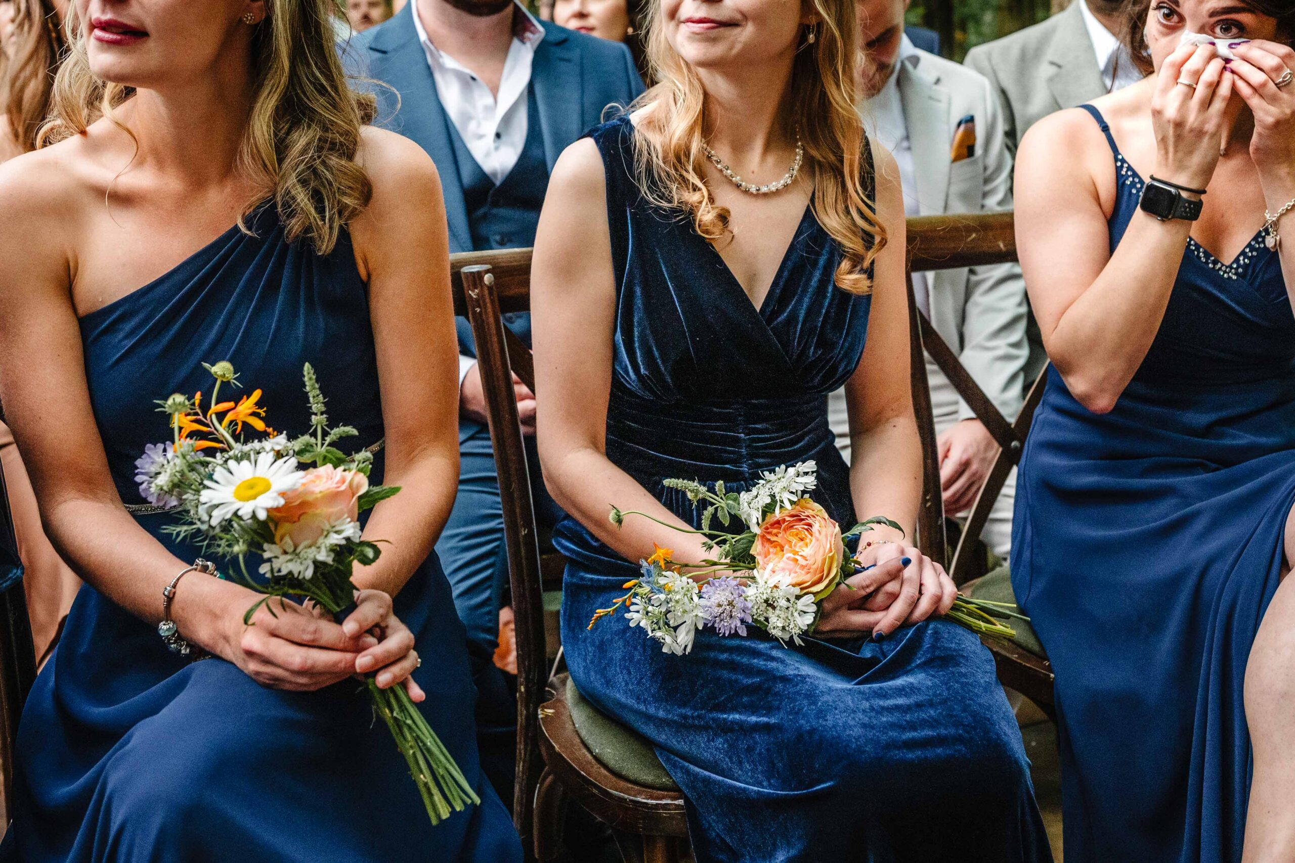 Bridesmaids holding bouquets during an outdoor wedding ceremony in Kent.