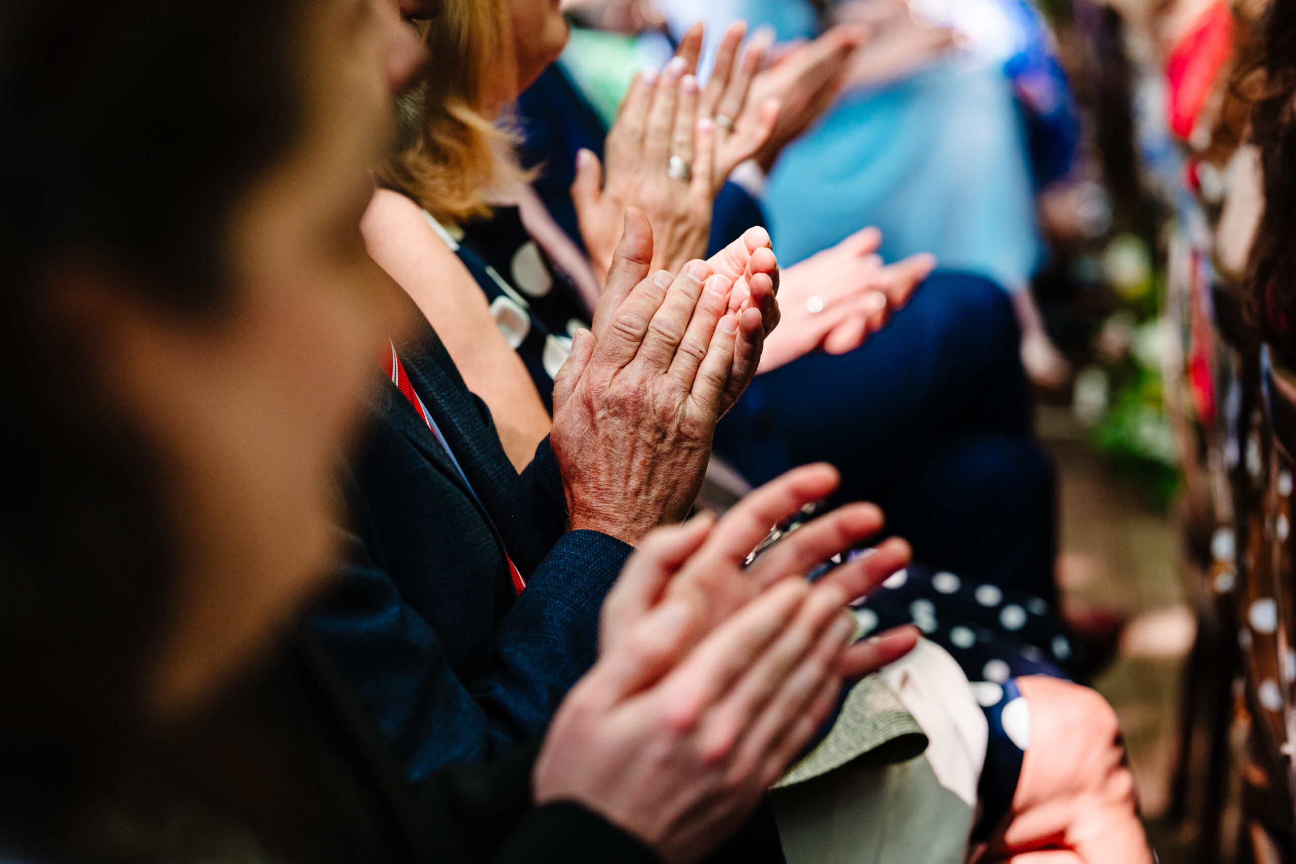 Wedding guests applauding during an outdoor woodland wedding ceremony in Kent.