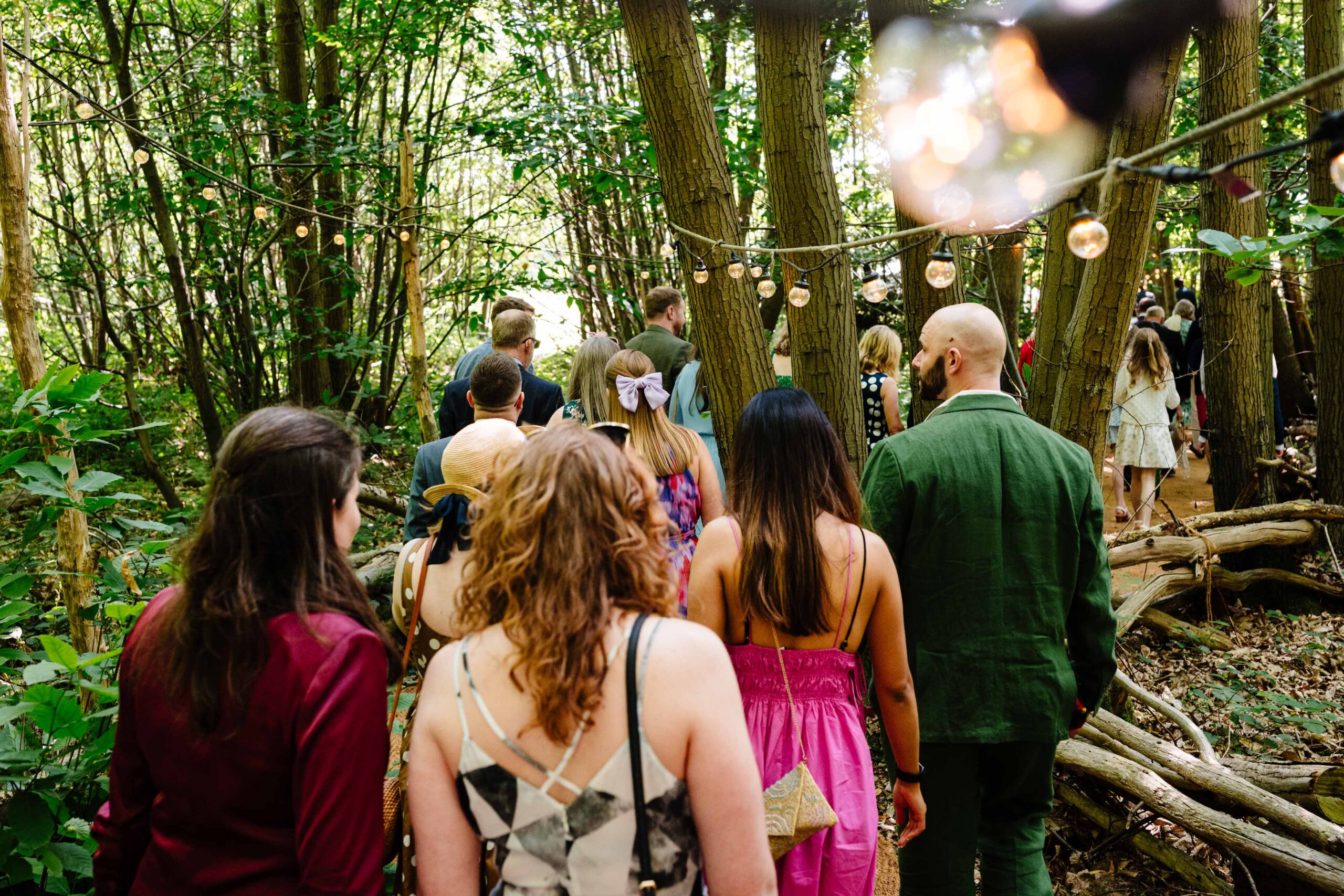 Guests watching the ceremony from the woodland aisle at The Dreys wedding venue.