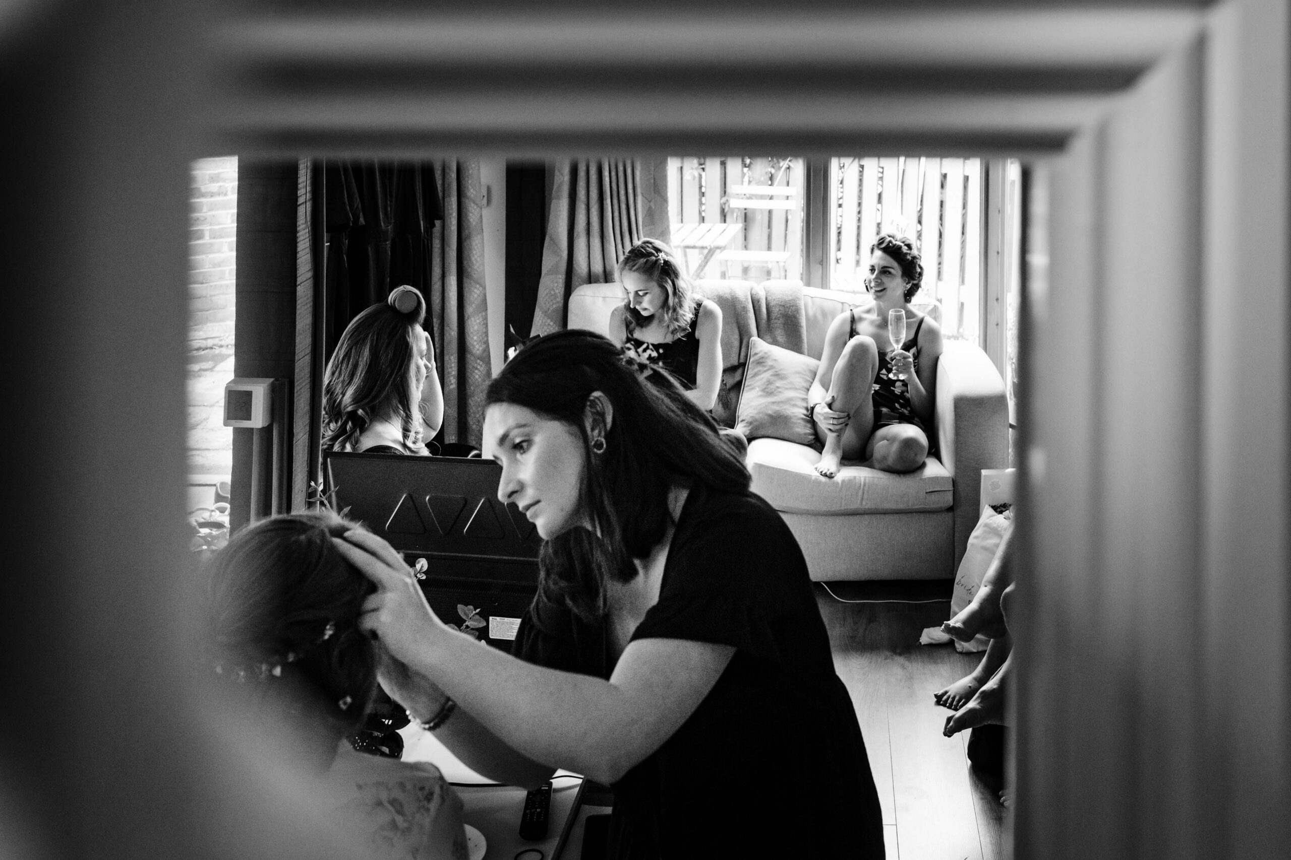 Bridesmaids helping the bride prepare on the morning of a relaxed wedding at The Dreys in Kent.