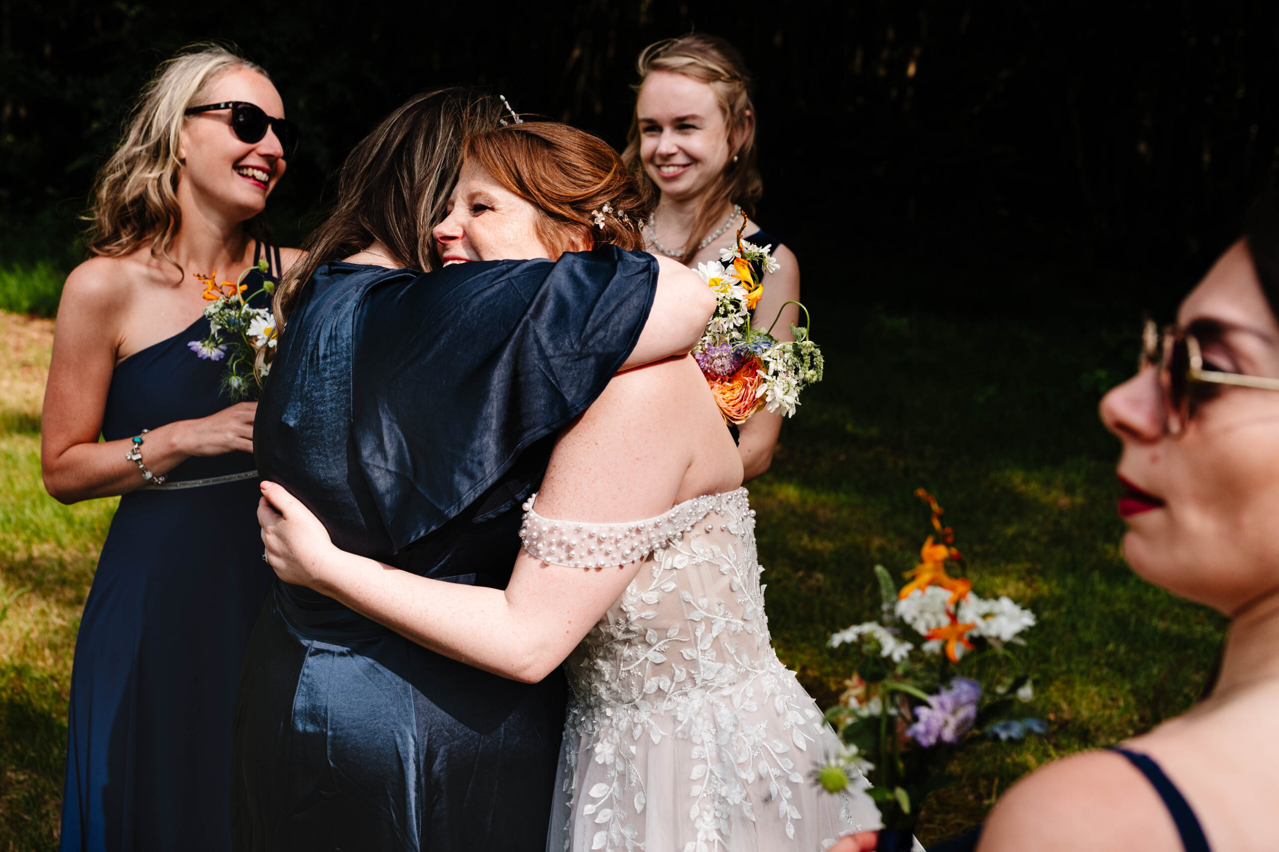 Wedding guests sharing a hug during a relaxed reception at The Dreys.