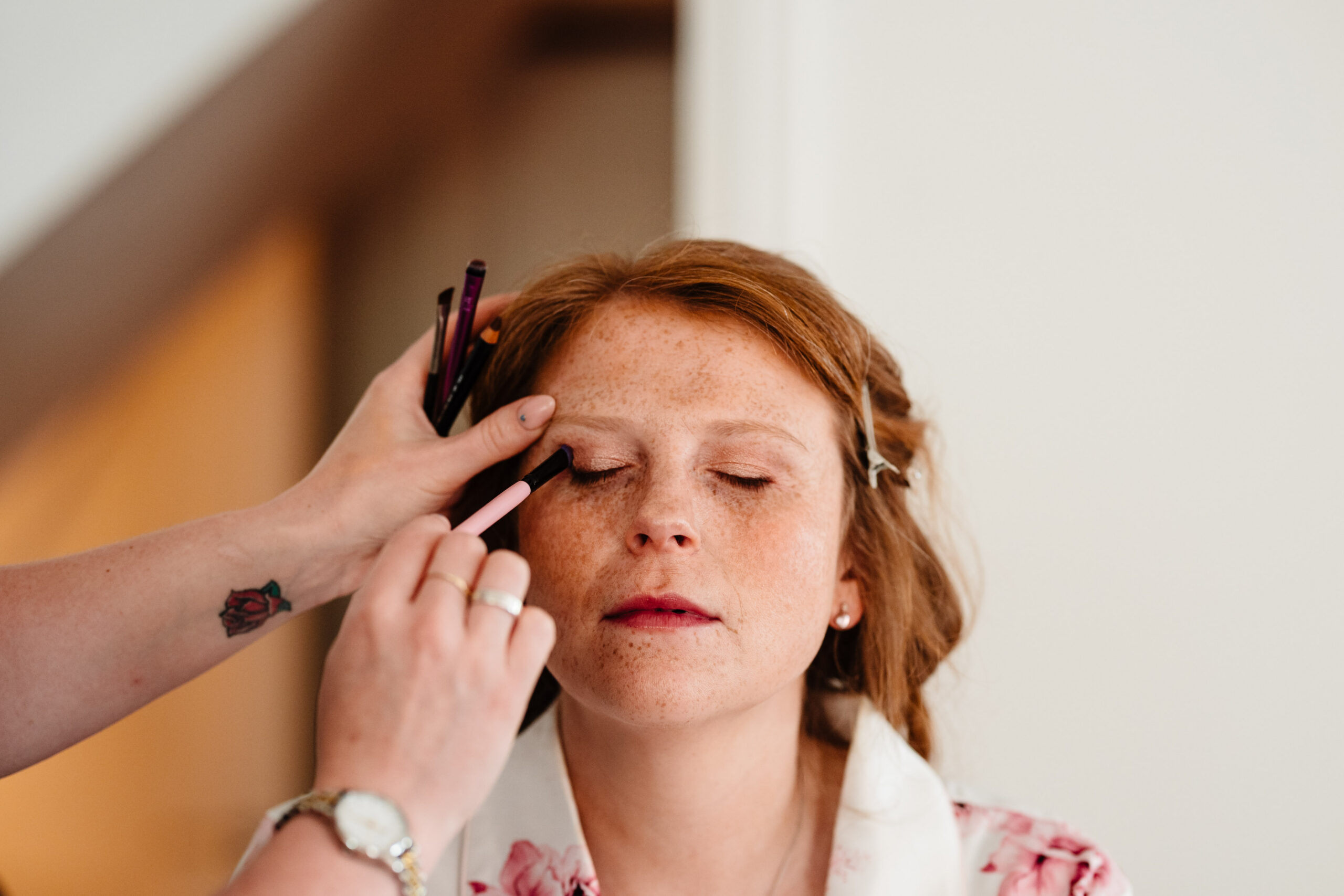 Close-up of bridal makeup being applied during wedding preparations at The Dreys wedding venue.