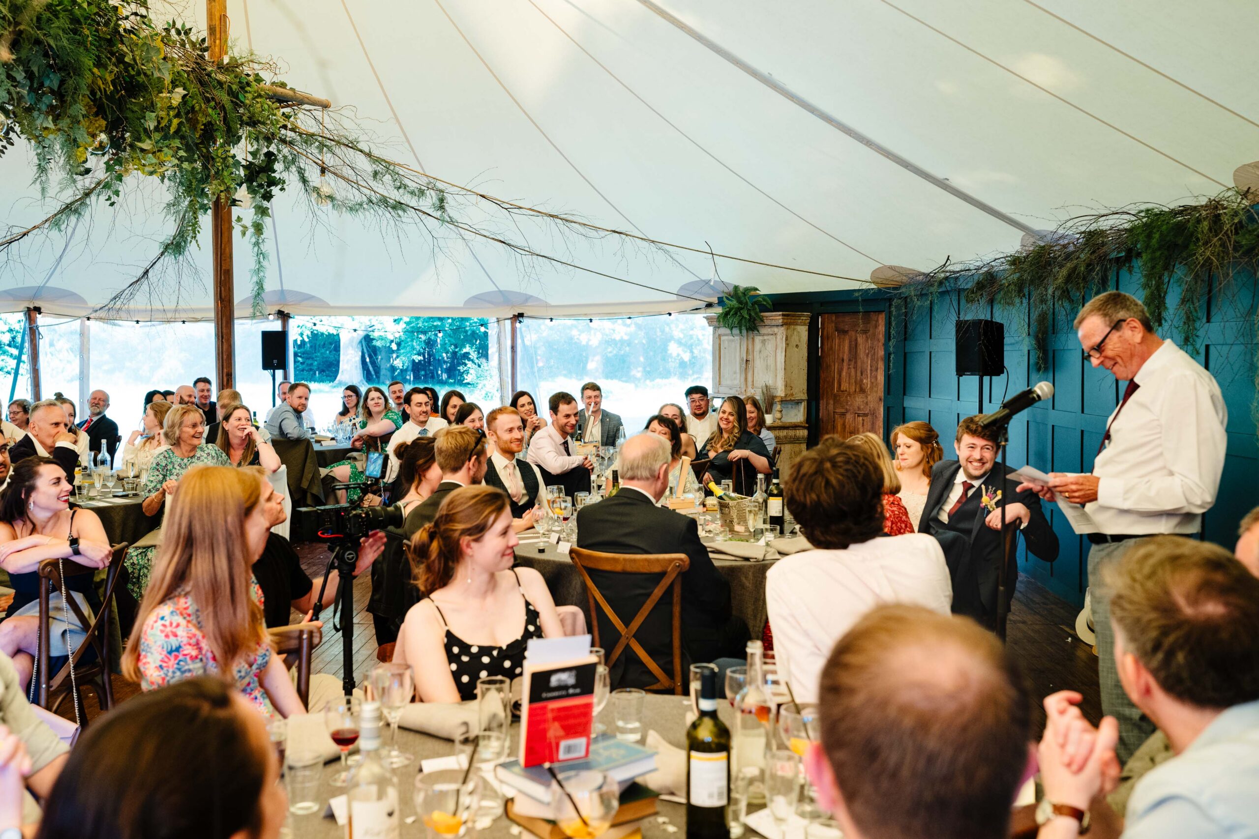 Guests listening to speeches inside the wedding marquee at The Dreys.
