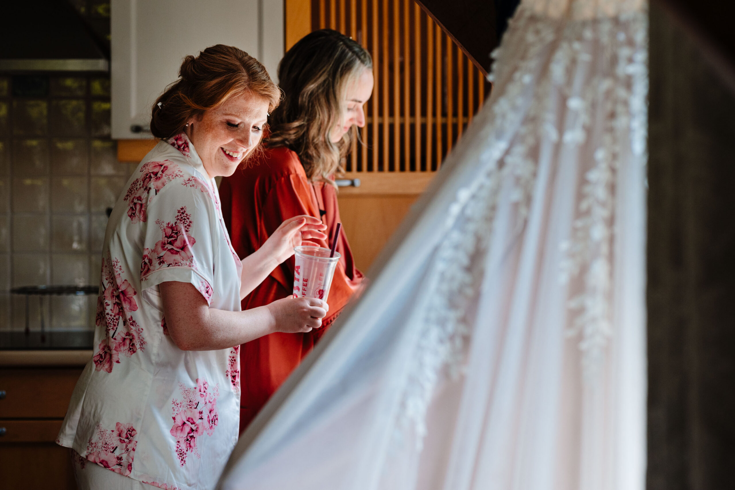 Bride and bridesmaid sharing a moment while getting ready for their woodland wedding in Kent.
