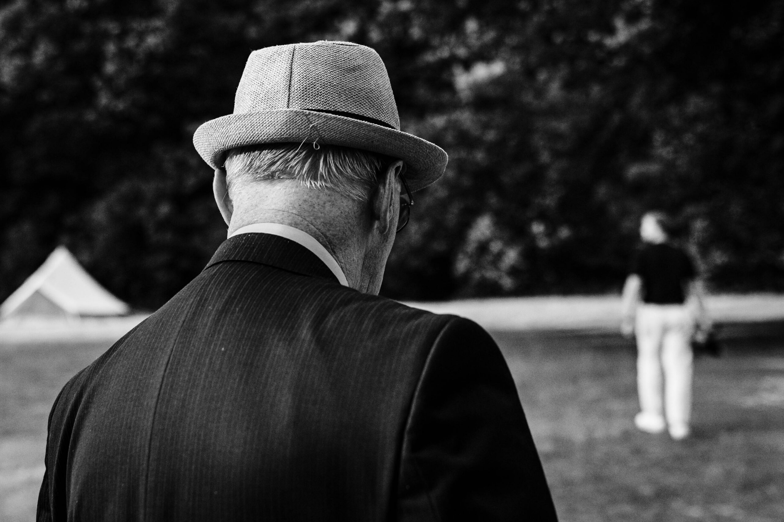 Wedding guest wearing a hat during a relaxed outdoor wedding reception in Kent.
