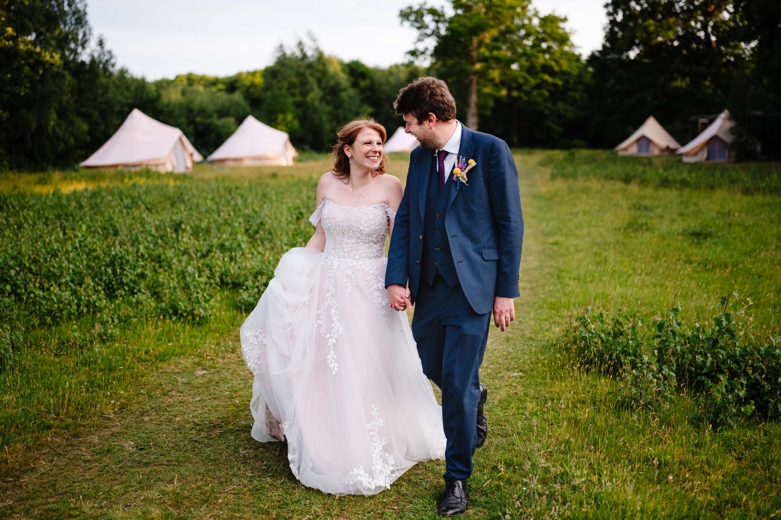 Bride and groom walking together across the grounds of The Dreys wedding venue.