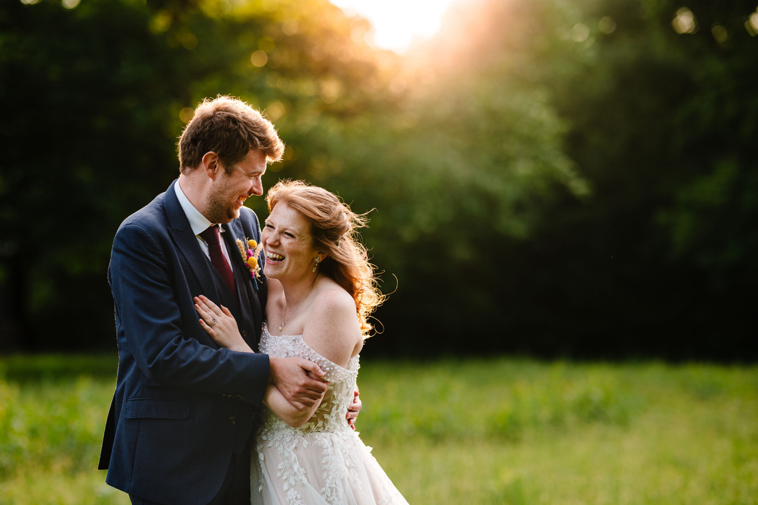 Bride and groom embracing during golden hour portraits at The Dreys in Kent.