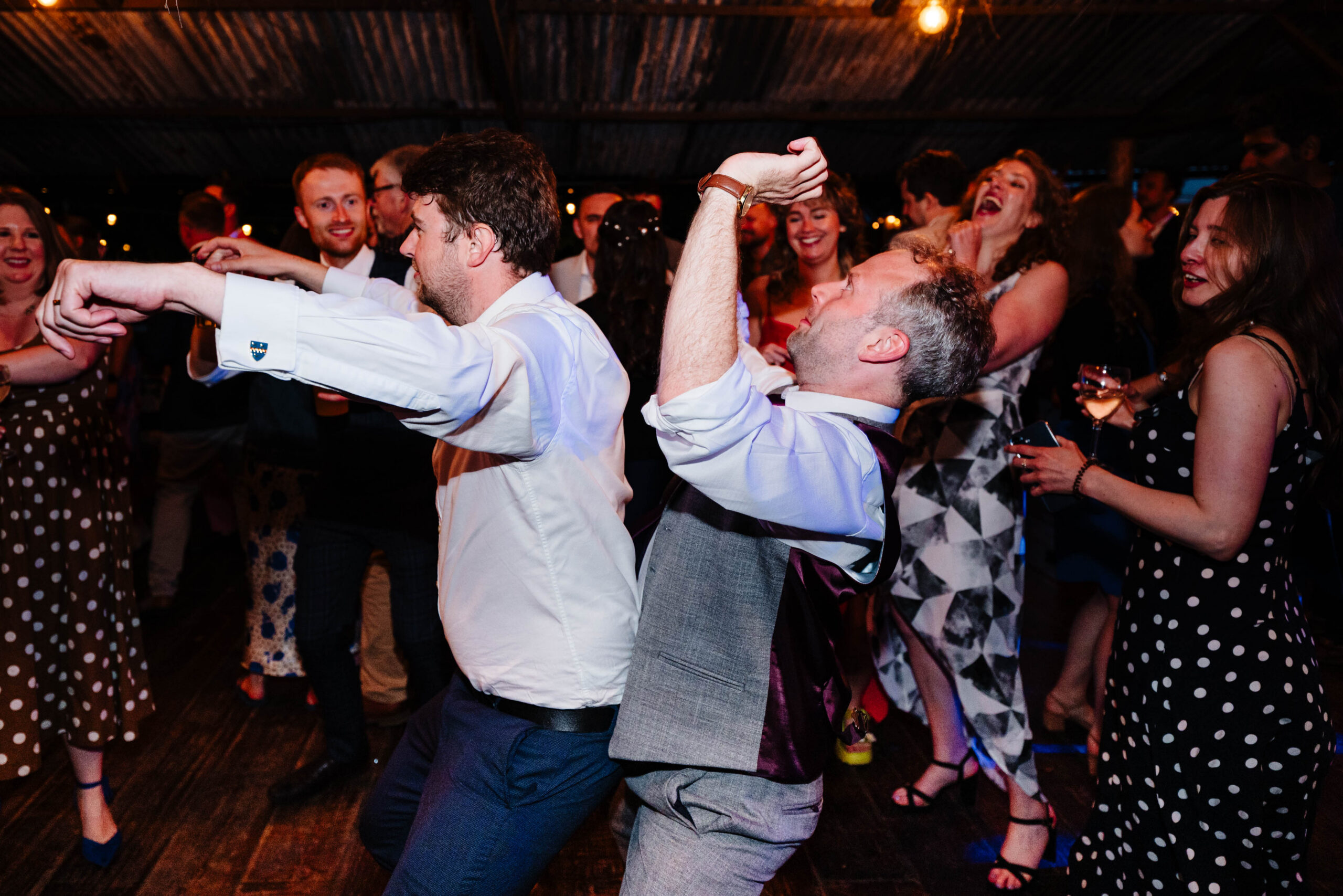 Wedding guests dancing enthusiastically during the evening party in Kent.