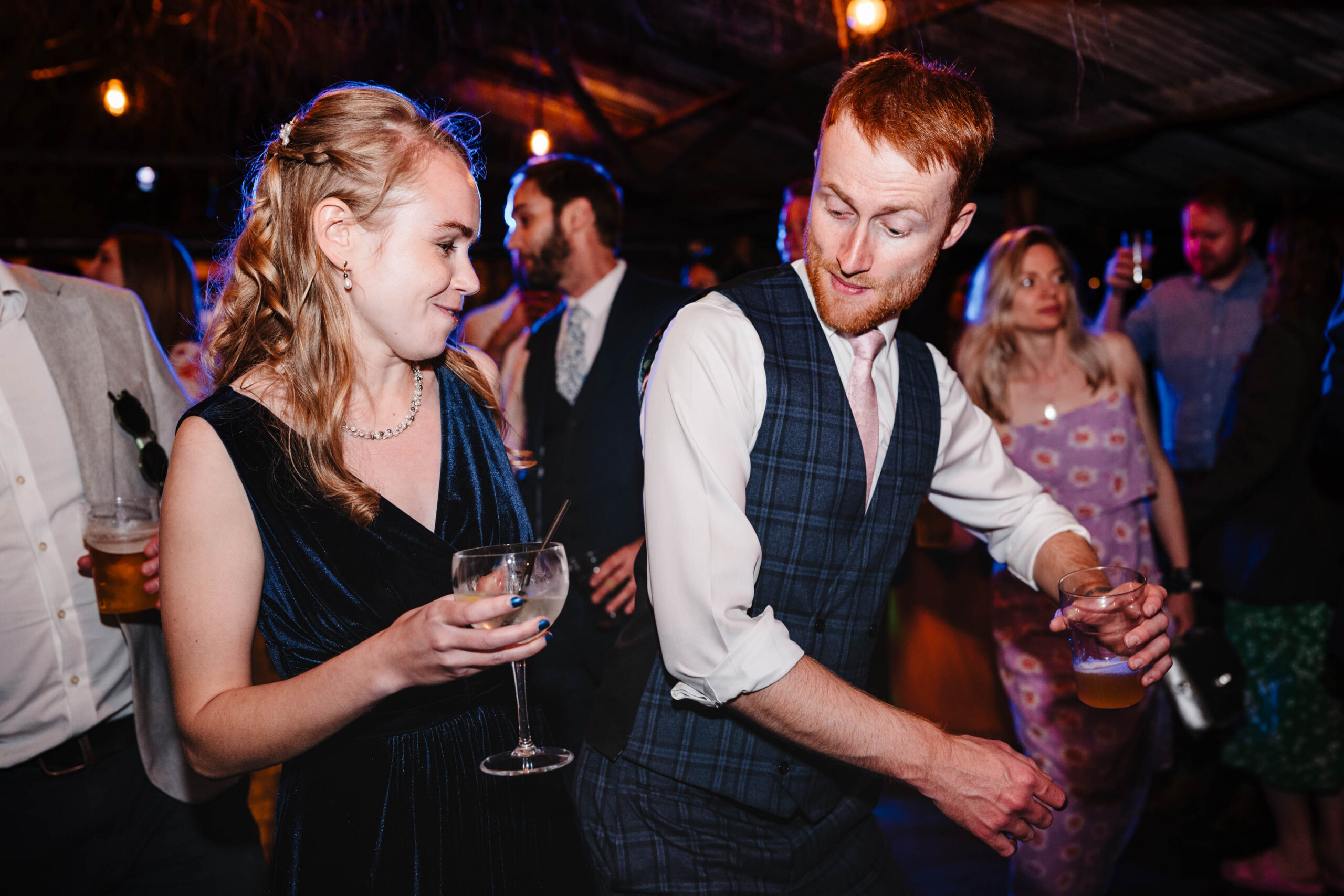 Wedding guests dancing together during a lively party at The Dreys wedding venue.