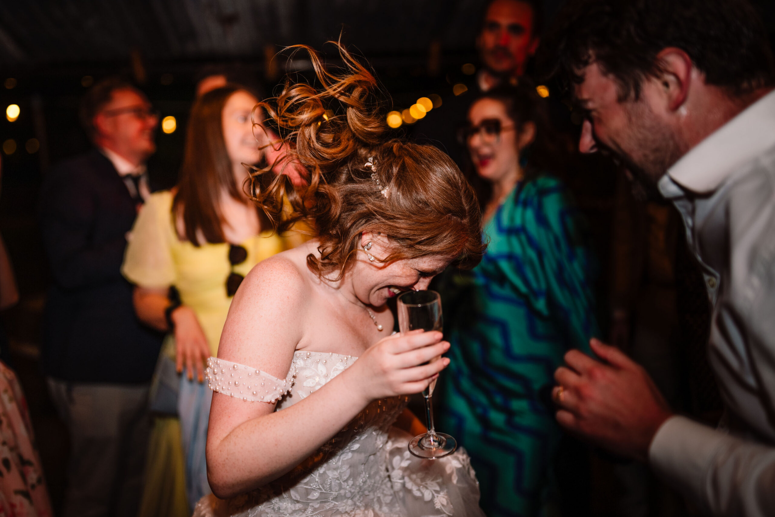 Bride laughing with guests on the dance floor during the evening reception.